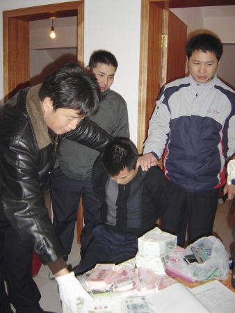 专案组民警在犯罪嫌疑人吴建辉住处搜出假币36万元.朱红梅 摄