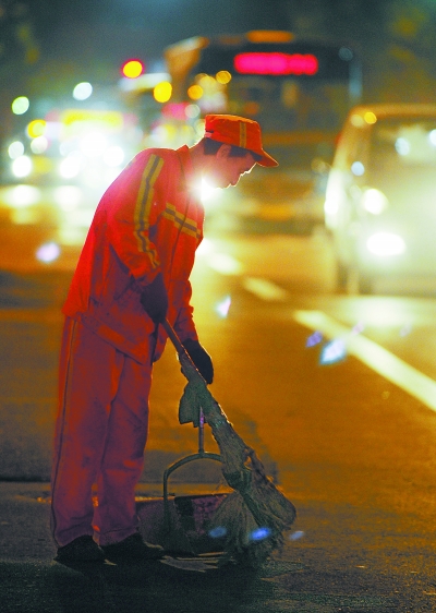 夜色中,环卫工人为城市清洁,奉献着自己的青春.