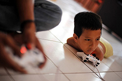 印尼无腿无臂男童用下巴玩游戏用嘴写字