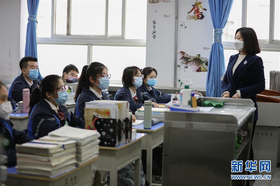 4月9日,兰州市第十学高三年级学生通过测温门进入教学楼.