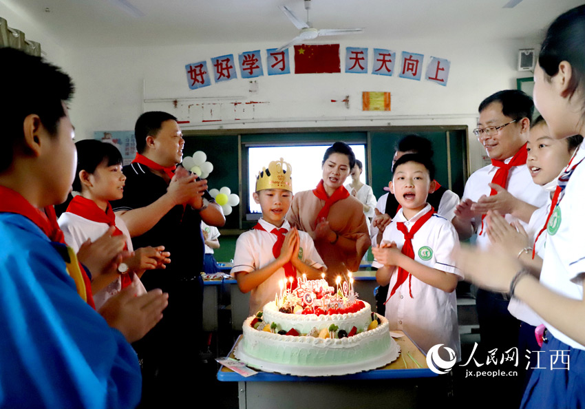 宜黄县实验小学师生与桃陂学校建档立卡贫困家庭学生一起唱生日歌。章英全摄