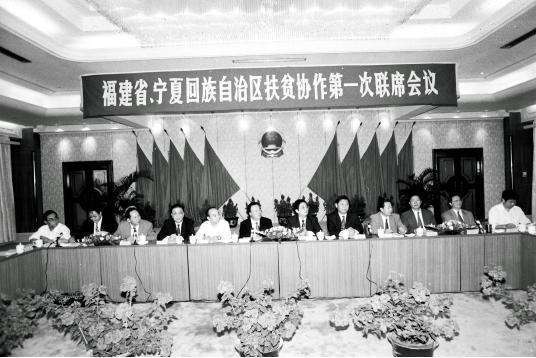 1996年11月，闽宁扶贫协作第一次联席会议在福建召开，会议确定：两省区政府每年举行一次联席会议；建立扶贫协作发展基金；从沿海5个省辖市中选出8个经济实力较强的县（市、区），对口帮扶宁夏8个国家扶贫开发工作重点县；互派挂职干部；部门对口协作。图为习近平（右五）出席闽宁扶贫协作第一次联席会议。 新华社记者 刘泉龙 摄.jpg?x-oss-process=style/w10