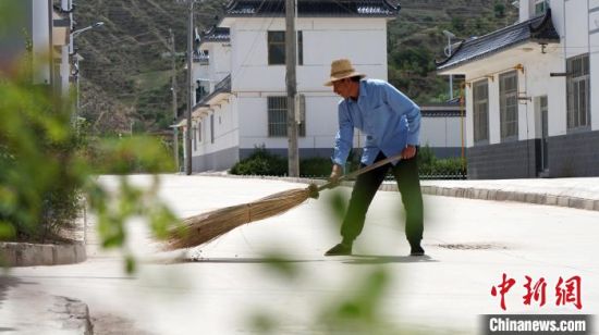 图为张彦慧清扫马路。　魏建军 摄