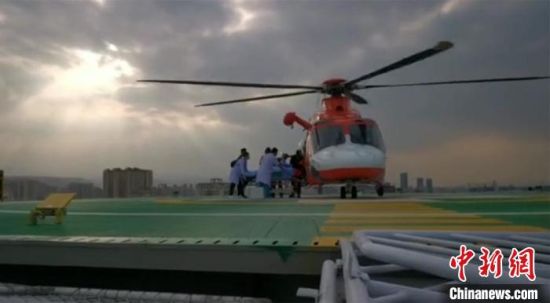 图为直升机在兰州大学第二医院楼顶停机坪降落，伤员以最快速度被送至ICU病房接受治疗。　甘肃省公航旅供图