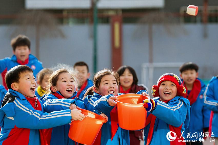 12月23日，内蒙古呼和浩特市玉泉区通顺街小学学生在大课间玩沙包抛接游戏。