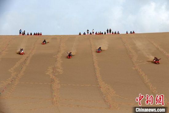 6月13日，敦煌鸣沙山月牙泉景区举办滑沙比赛。　张晓亮 摄