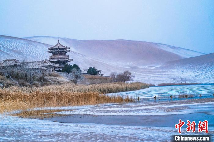 2021年11月28日，雪落鸣沙山月牙泉景区。　王斌银 摄