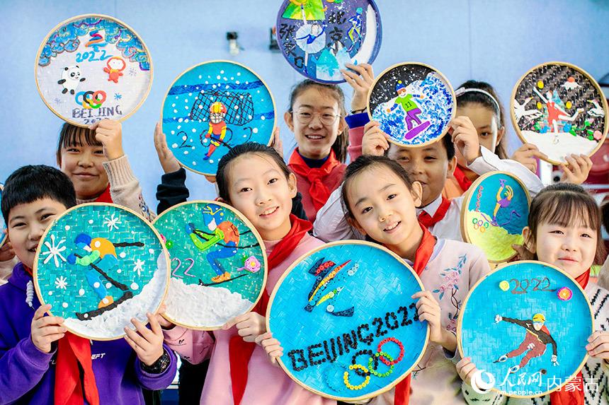 12月22日，内蒙古呼和浩特市玉泉区恒昌店巷小学学生在展示自己绘制的以冰雪运动为主题的儿童画。丁根厚摄