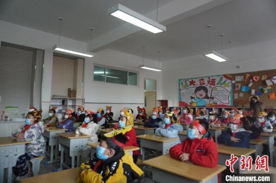 图为2月23日，北京第二实验小学，学生们头戴“虎元素”饰品，开启开学第一课。　九美旦增 摄