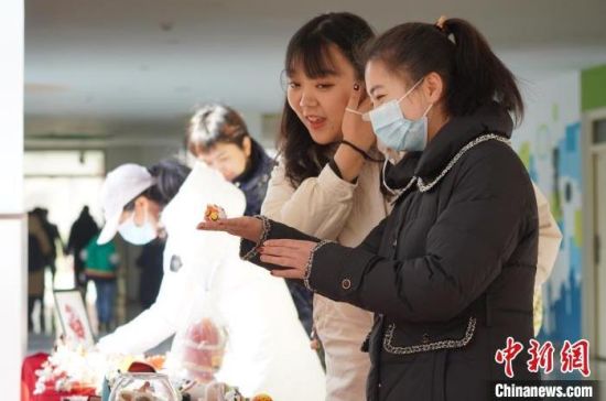 图为北京第二实验小学的学生在寒假期间制作的手工作品展吸引学校老师驻足观看。　九美旦增 摄