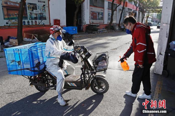 资料图：京东物流上海虹口营业部，快递人员正在对回来的电动自行车进行消毒作业。 <a target='_blank'  data-cke-saved-href='/' href='/'>中新社</a>记者 殷立勤 摄