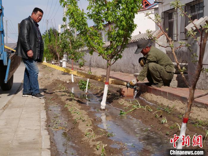 图为村民为刚栽上的地瓜苗浇水。　郭大蕾 摄