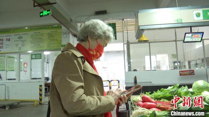 胡晖用手机扫码买菜 冯佳飞 摄