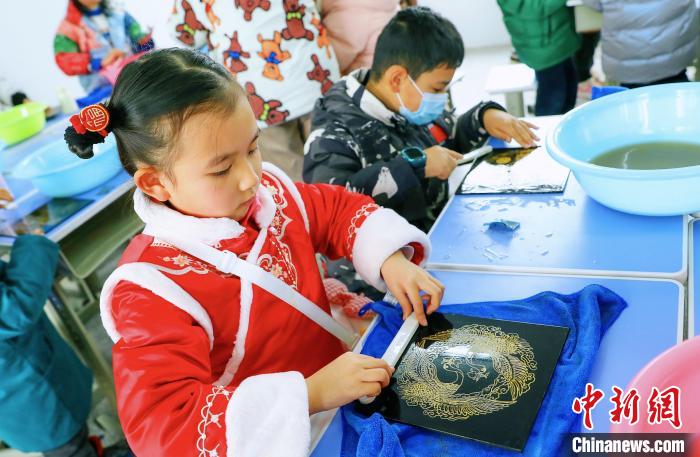 一名小学生正在体验水磨漆髹饰技艺 梅珂 摄