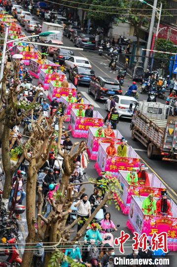 图为“装马匹”民俗巡游队伍穿过城市街道。　骆云飞 摄