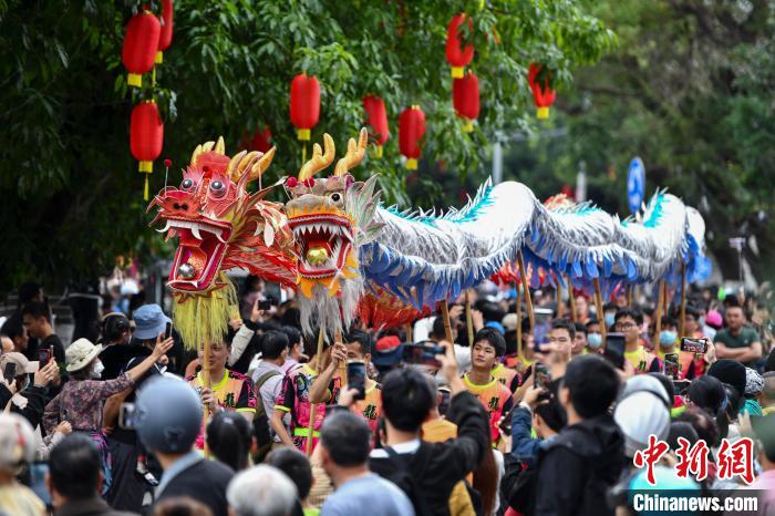 图为“装马匹”民俗巡游队伍中的舞龙方阵，吸引民众围观。　骆云飞 摄