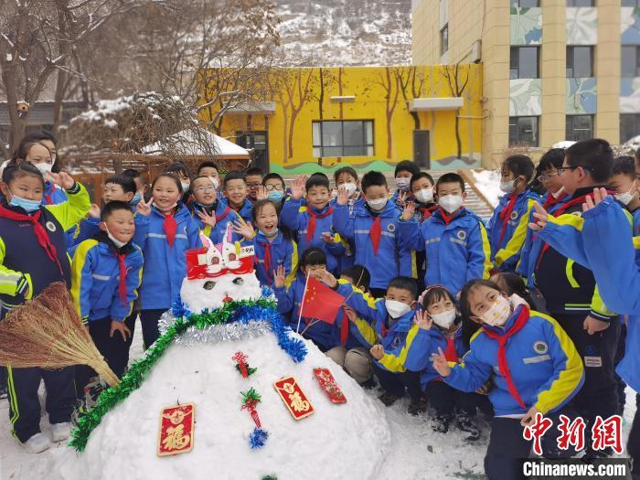 图为兰州西北新村小学师生比赛堆雪人，体验“雪中第一课”。　闫姣 摄