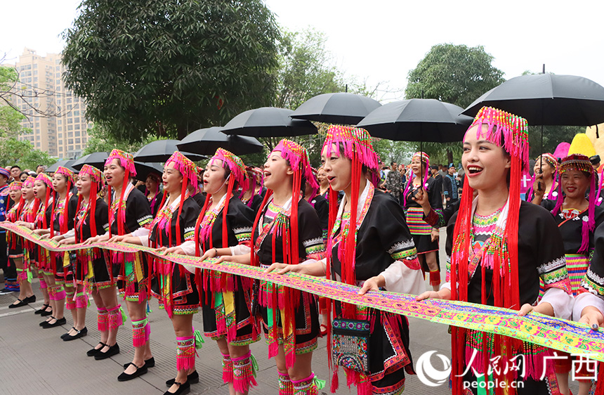 行至半路，就遇上了“拦路关”。一众瑶族妇女拿着一根红线拦住路口，唱起了拦路歌。人民网记者 彭远贺摄