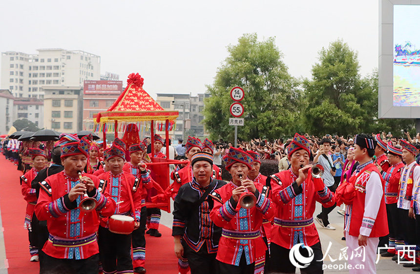 随后，新娘由其舅舅背着出门，坐上轿子，队伍出发前往拜堂仪式举行地。人民网记者 彭远贺摄