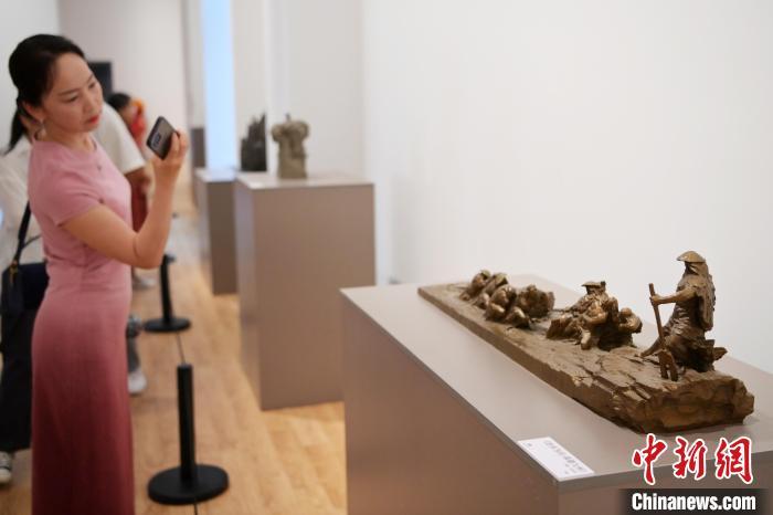 5月21日，参观者手机拍摄在“丝路印迹”雕塑艺术作品展展出的作品《治水为民·禹德九州》。九美旦增 摄</p>
<p>