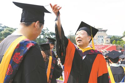 2017年6月22日，李德仁（右一）参加武汉大学毕业典礼并为毕业生拨穗。