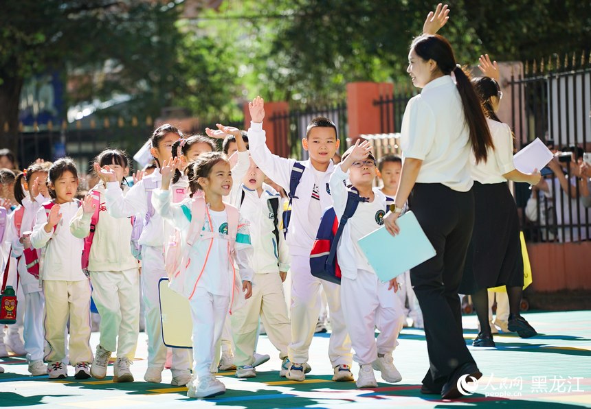 哈尔滨市红岩小学一年级新生在老师的指引下有序进入校园。人民网记者 苏靖刚摄