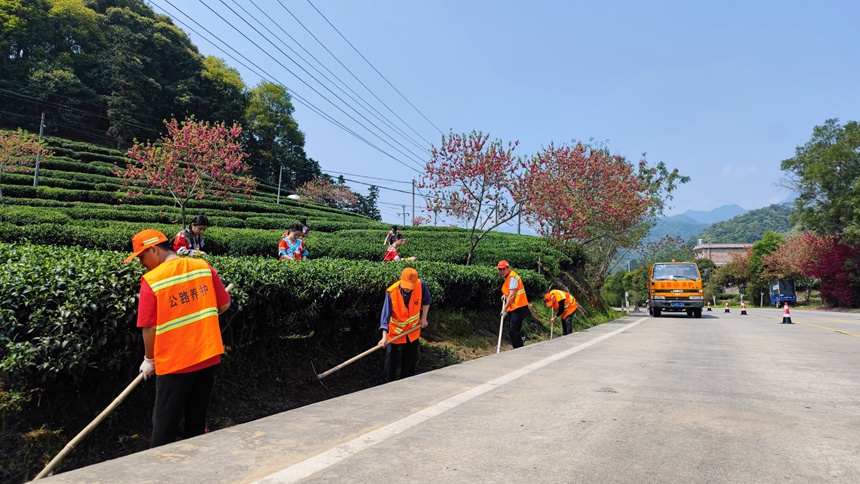 国道241线昭平县西坪茶园路段公路养护人员正在清理路肩杂物。广西公路发展中心供图