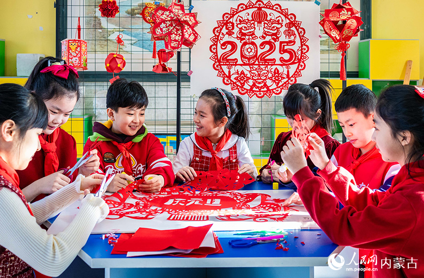 呼和浩特市玉泉区五塔寺东街小学学生在制作迎新年剪纸作品。丁根厚摄