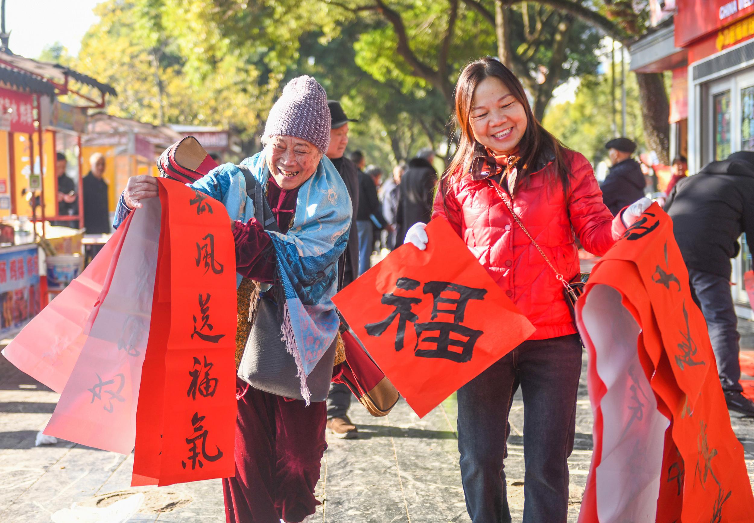 2025年1月13日，在湖南省永州市道县西洲公园义工岗亭，市民们领到了书法志愿者为大家书写的春联。